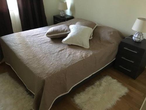 a bed with two pillows on it in a bedroom at Aroeira Golf in Charneca