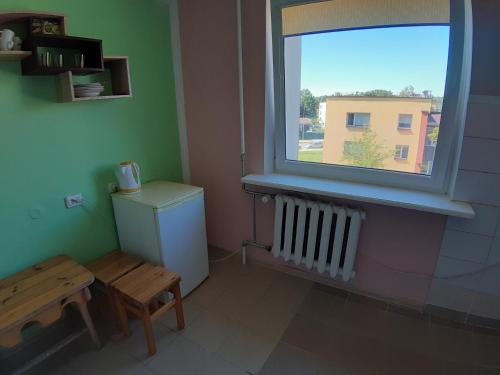 een kamer met een raam, een tafel en een radiator bij Independent apartment in varena in Varėna I