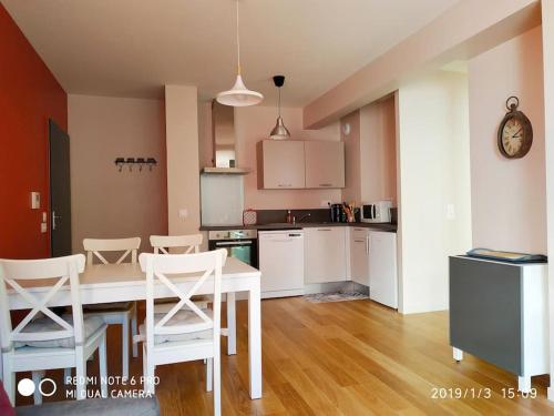 une cuisine avec une table et des chaises dans une pièce dans l'établissement Grand T2 récent, confort 4*, vue superbe., à Le Mont-Dore