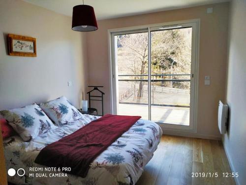 une chambre avec un lit et une grande fenêtre dans l'établissement Grand T2 récent, confort 4*, vue superbe., à Le Mont-Dore