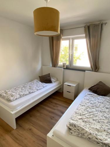 1 dormitorio con 2 camas y ventana en 3-Zimmer Wohnung mit Top Lage, en Giessen