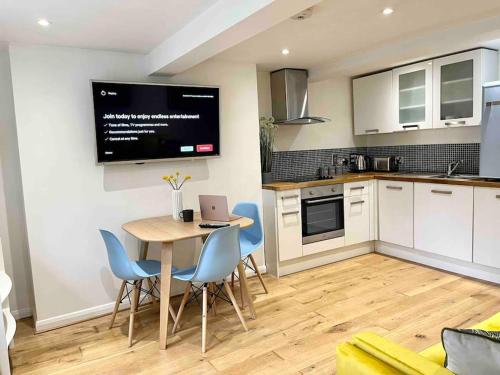 a kitchen with a table with chairs and a laptop on it at Forbury Apartment, 3 guests, Free Parking & Wifi, close to Uni, Hospital & Town Centre in Reading