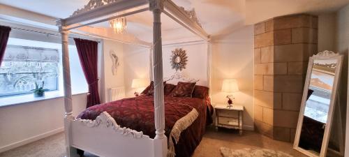 a bedroom with a canopy bed and a mirror at LOCH NESS - Luxury Highland Retreat in Scotland in Fort Augustus