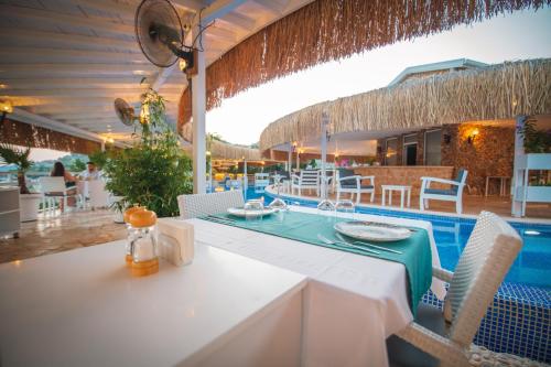 a white table and chairs next to a swimming pool at Likya Pavilion Hotel in Kas