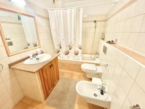 a bathroom with a sink and a toilet and a mirror at Casa Cecilia in Playa de San Juan