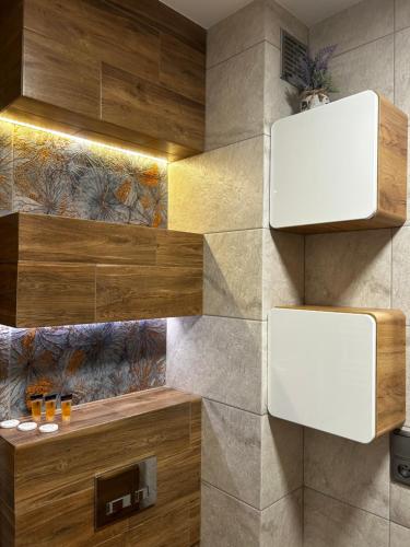 ein Bad mit einer Wand mit Holz und Fliesen in der Unterkunft M&M Apartament Glogera in Krakau