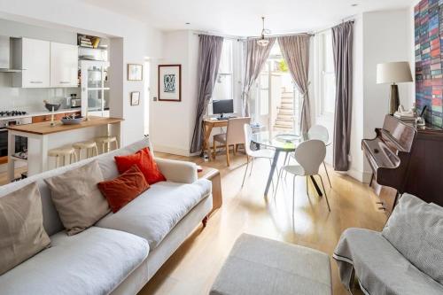 een woonkamer met een bank en een keuken bij Superior 5* Kensington, London Flat + Free Wi-Fi in Londen