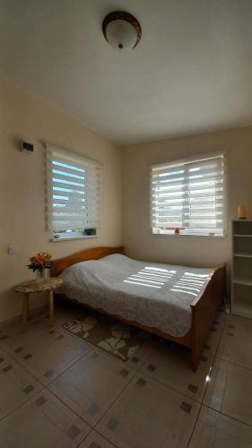 1 dormitorio con 1 cama grande y 2 ventanas en SweetHome, en Limbaži