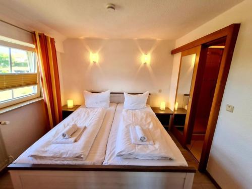ein Schlafzimmer mit einem Bett mit zwei Handtüchern darauf in der Unterkunft Boddenhus Apartment in Gager