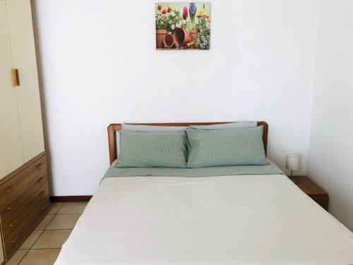 1 cama en un dormitorio con una foto en la pared en Casa Nonna Elide 2, en Besozzo