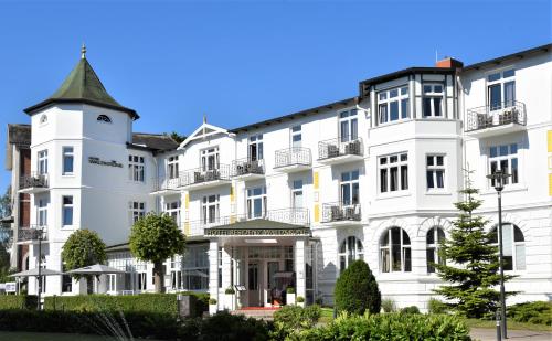 a large white building with a turret at Hotel Residenz Waldkrone Kühlungsborn in Kühlungsborn