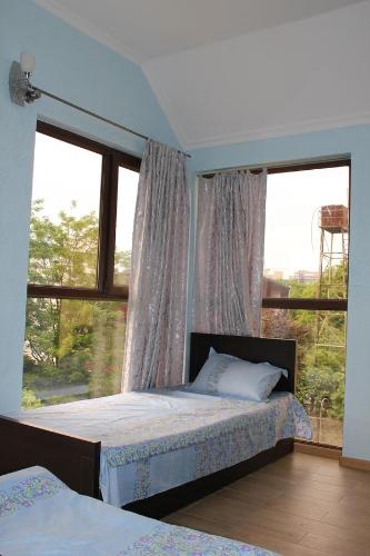 a bedroom with a bed and a large window at Guest House Kobuleti in K'obulet'i