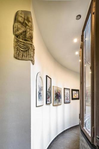 a hallway with a statue on a wall with pictures at Boutique Hotel Piazza Carità in Naples