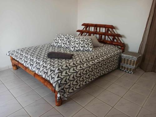 a bed with two pillows on it in a room at Bosofet Beach and Creek Lodge in Sanyang