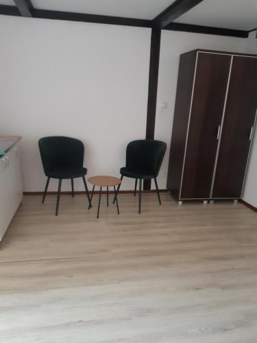 three chairs and a table in a room at Apartamenty pod Kicarzem in Piwniczna-Zdrój
