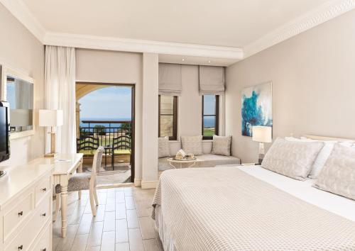 een slaapkamer met een bed en een woonkamer bij Atlantica Aphrodite Hills Hotel in Kouklia