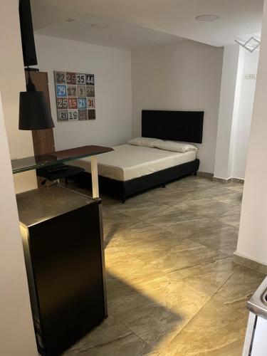 Habitación con cama y mesa de cristal. en Apartamento con aire acondicionado al lado de la Unidad Deportiva de Belén y a 10 minutos de Plaza Mayor - 2, en Medellín