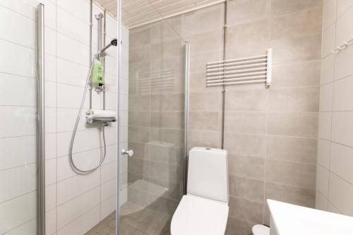 a bathroom with a shower with a toilet and a sink at Hiisi Homes Riihimäki in Riihimäki