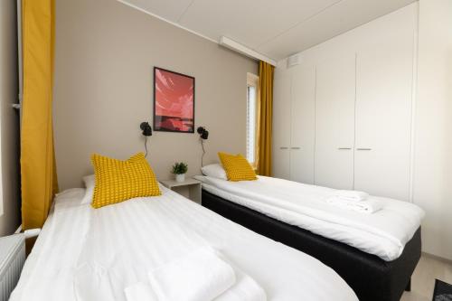 2 Betten nebeneinander in einem Zimmer in der Unterkunft Hiisi Homes Riihimäki in Riihimäki