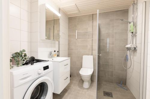 a white bathroom with a toilet and a shower at Hiisi Homes Riihimäki in Riihimäki