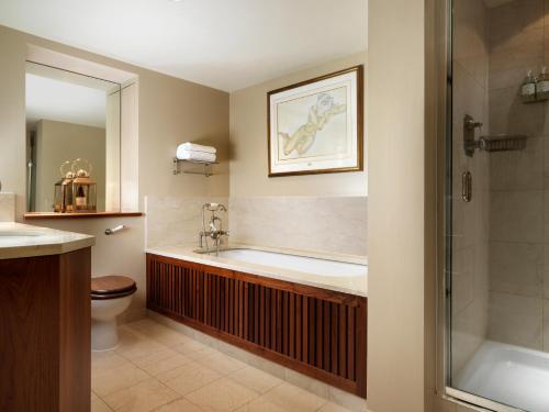 ein Bad mit einer Badewanne, einem Waschbecken und einer Dusche in der Unterkunft The Vineyard Hotel & Spa in Newbury