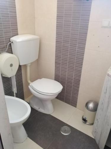 a bathroom with a white toilet and a sink at Bela Vista in Olhão