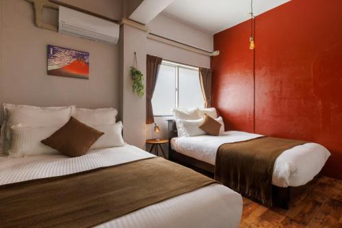 a hotel room with two beds and a window at Residential Hotel Naha Miebashi in Tomari