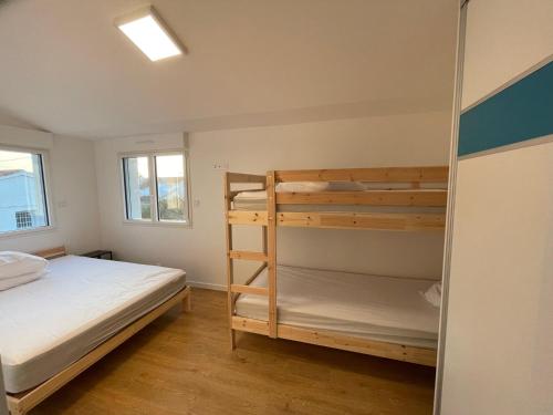 1 dormitorio con 2 literas y ventana en La maison d'Ilaude de 7 à 14 personnes, en Saint-Hilaire-de-Talmont