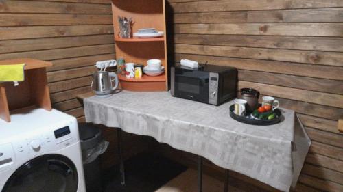 a table with a microwave and a bowl of fruit on it at Glamping Fluffy Horns - Glempings Pūkainie Ragi in Plieņciems