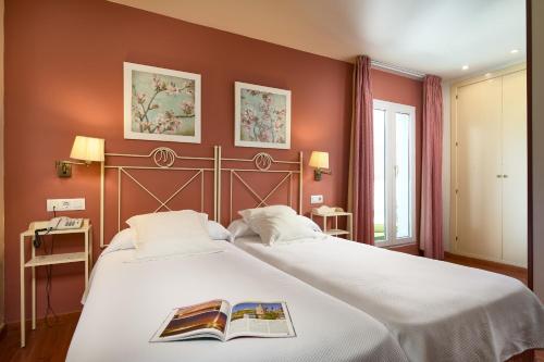 Un dormitorio con una cama grande con un libro. en Hotel Murillo, en Sevilla