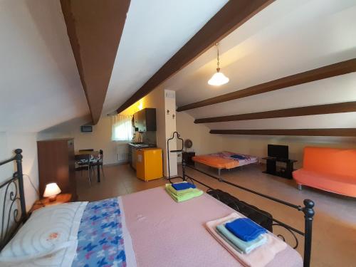 een slaapkamer met een bed en een bank in een kamer bij Villa Maria Pia in Montebello di Bertona