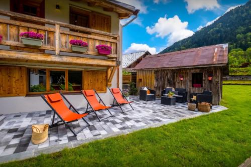 - un ensemble de chaises sur une terrasse en face d'une maison dans l'établissement Chalet 65bis - OVO Network, à Thônes