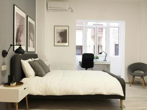 Schlafzimmer mit einem Bett, einem Schreibtisch und einem Stuhl in der Unterkunft Perfect Home: Cozy 2BR Apt & Balcony in Bukarest