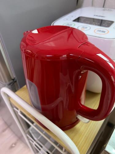 a red tea pot sitting on a shelf in a refrigerator at Sepia Court Inn セピアコートイン in Urayasu