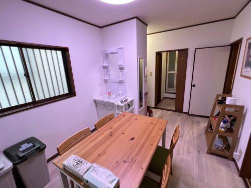 a dining room with a wooden table and chairs at Sepia Court Inn セピアコートイン in Urayasu