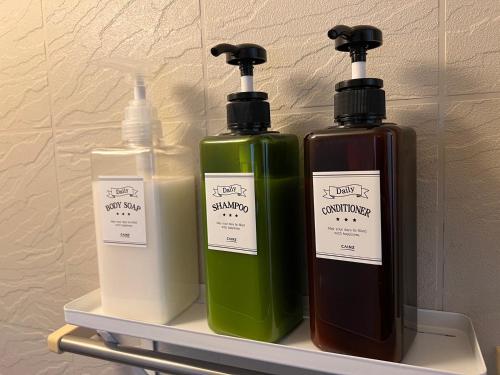two bottles of soap on a shelf in a bathroom at Sepia Court Inn セピアコートイン in Urayasu