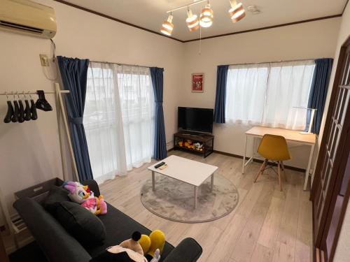 a living room with a couch and a table at Sepia Court Inn セピアコートイン in Urayasu