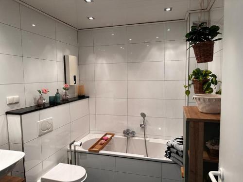 ein weißes Bad mit einer Badewanne und einem WC in der Unterkunft A&V Apartments Wunderschöne Rheinblick Wohnung zum entspannen in Duisburg