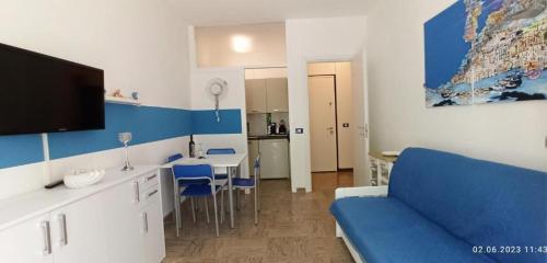 a living room with a blue couch and a kitchen at Residence Pineda A 6 in Bibione