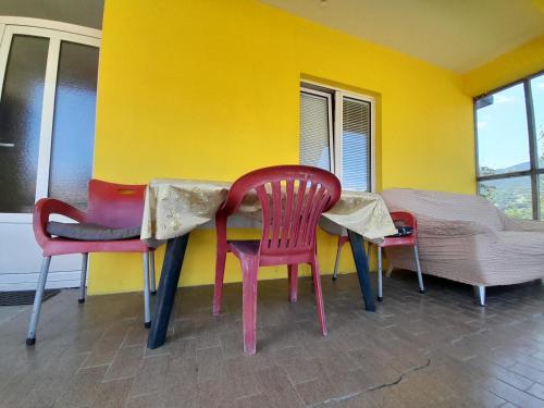 Tina apartman في باغينا باستا: طاولة وكراسي في غرفة بجدار اصفر