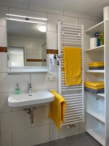 a bathroom with a sink and a mirror and yellow towels at Fewo Belinda, Tiengen Zentrum in Waldshut-Tiengen