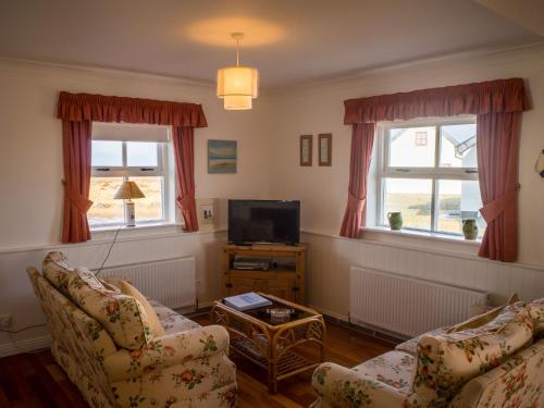 a living room with two couches and a tv at 14 Leitirshask, Ballyconneely in Ballyconneely