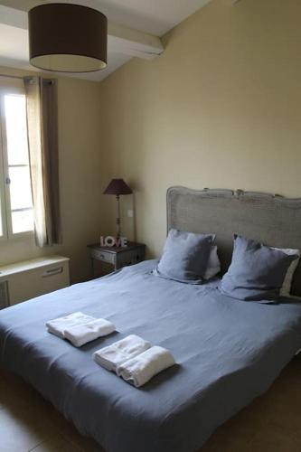 une chambre avec un lit avec deux serviettes dessus dans l'établissement Maison provençale en Corbières, à Saint-Laurent-de-la-Cabrerisse
