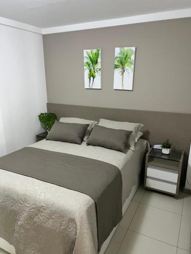 ein Schlafzimmer mit einem Bett mit zwei Palmen an der Wand in der Unterkunft Beach Class Slin Muro Alto in Porto De Galinhas