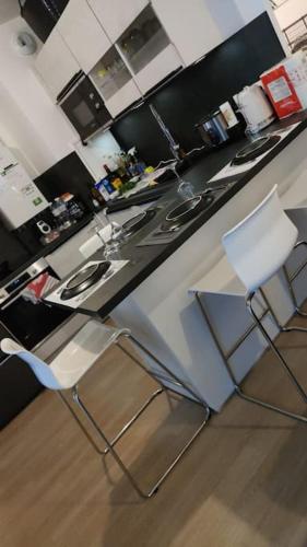 cocina con 2 sillas y encimera en Logement YJR, en Pierrefitte-sur-Seine