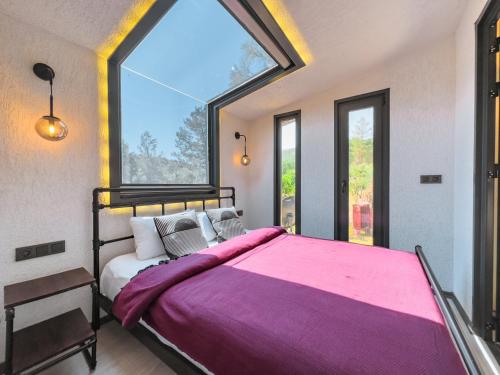 a bedroom with a large bed with a large window at Mossa Afkule Kayaköy in Fethiye