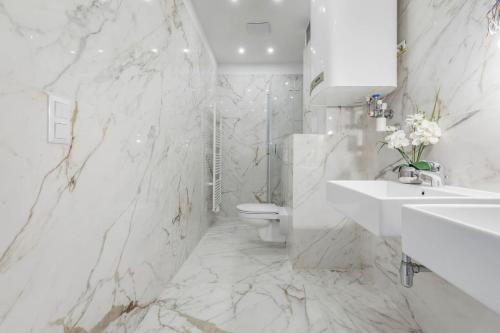 a white marble bathroom with a toilet and a sink at Luxury Living Schloss Belvedere in Vienna