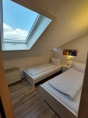 une chambre avec deux lits et un puits de lumière dans l'établissement Katya, à Winterberg