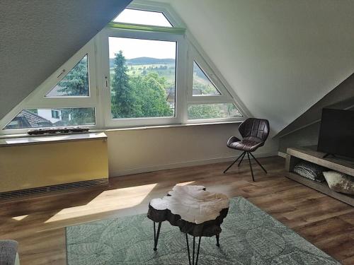 ein Wohnzimmer mit einem großen Fenster und einem Stuhl in der Unterkunft Katya in Winterberg