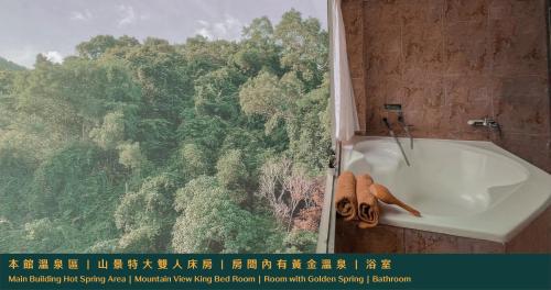 a bathroom with a bath tub in front of a window at Ruixiong Hotspring Hotel in Ruisui